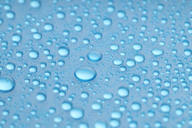 Photo of Water drops on blue background, closeup view