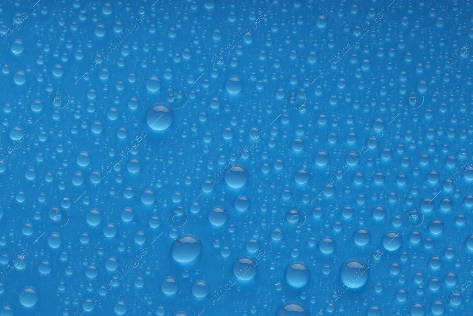 Photo of Water drops on blue background, top view