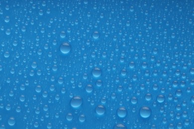 Photo of Water drops on blue background, top view