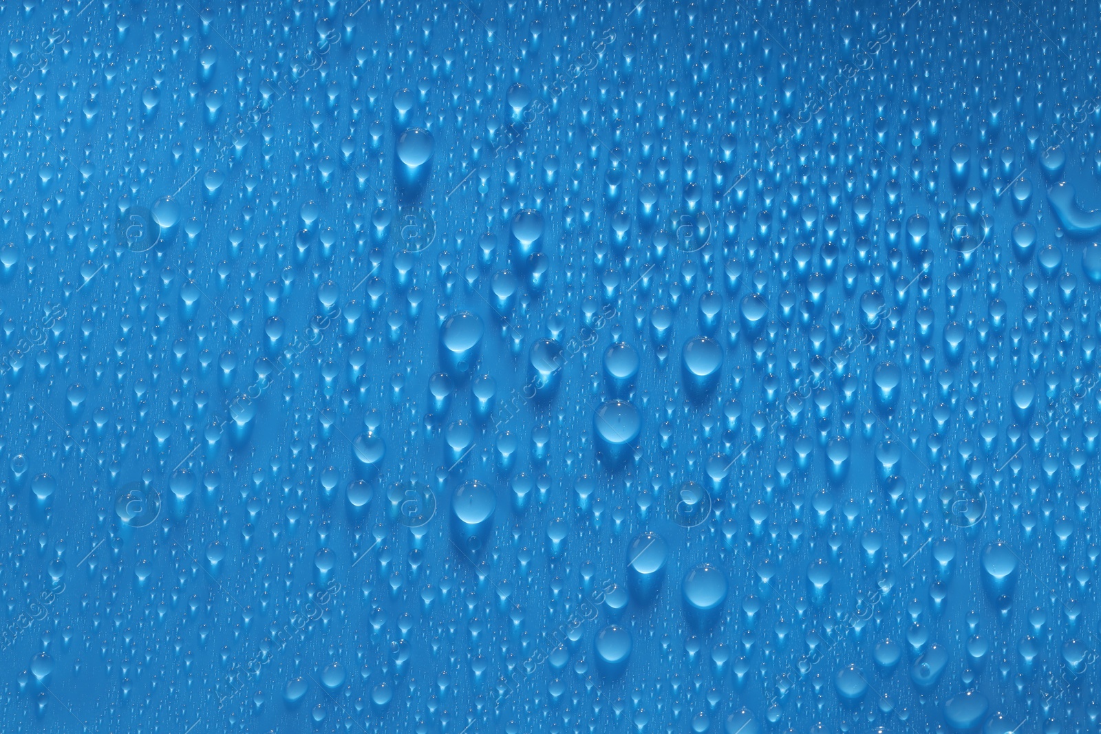 Photo of Water drops on blue background, top view