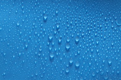 Photo of Water drops on blue background, top view