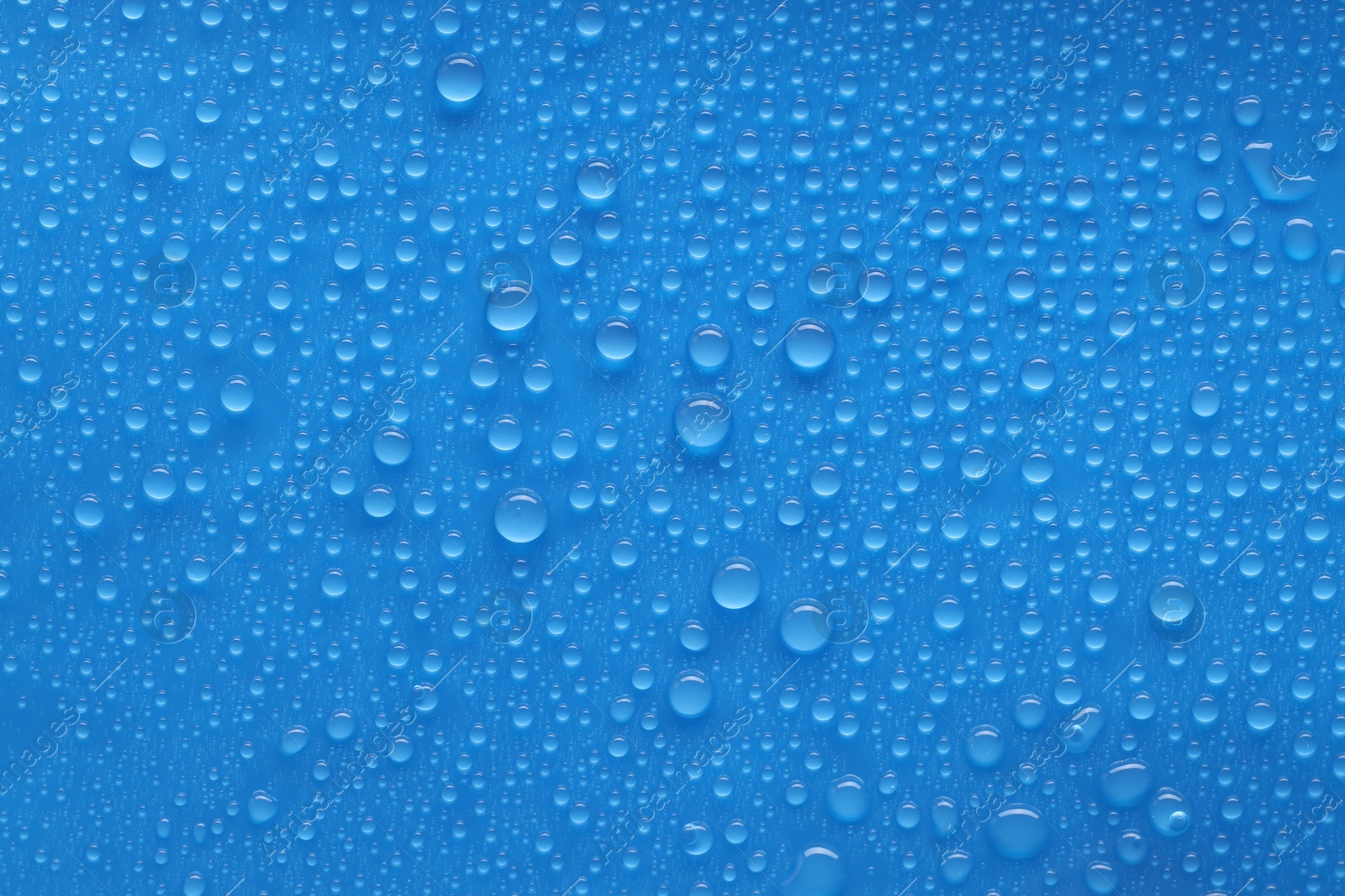 Photo of Water drops on blue background, top view