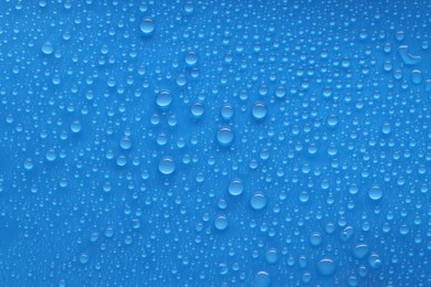 Photo of Water drops on blue background, top view