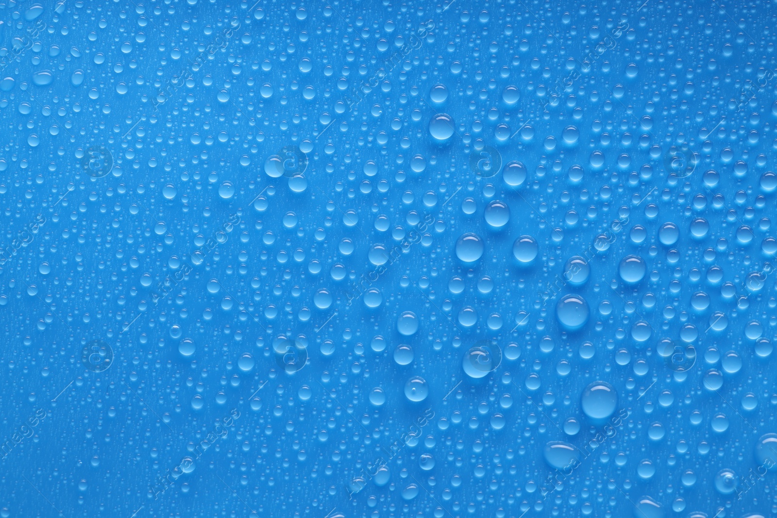 Photo of Water drops on blue background, top view