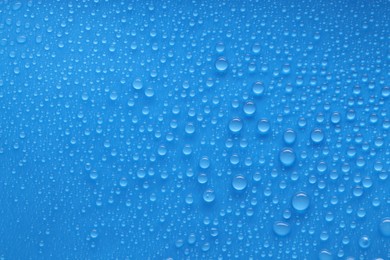 Photo of Water drops on blue background, top view