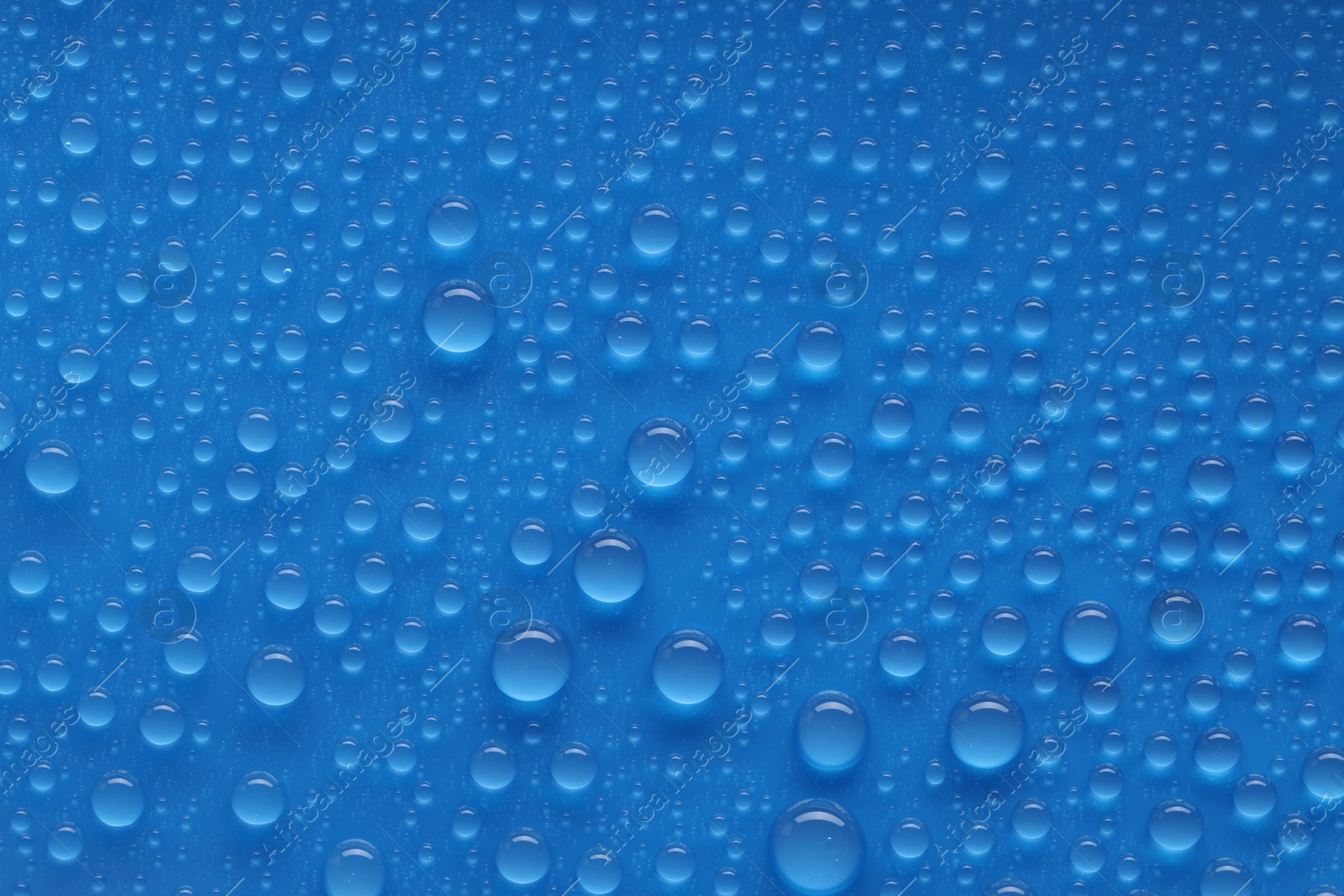 Photo of Water drops on blue background, top view