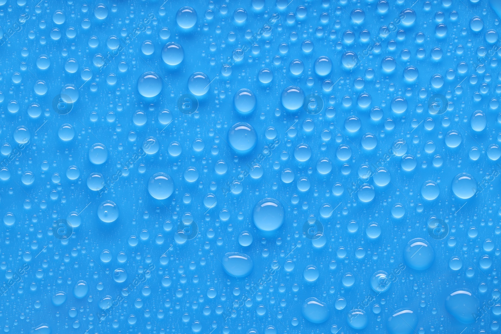 Photo of Water drops on blue background, top view