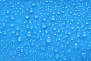 Photo of Water drops on blue background, top view