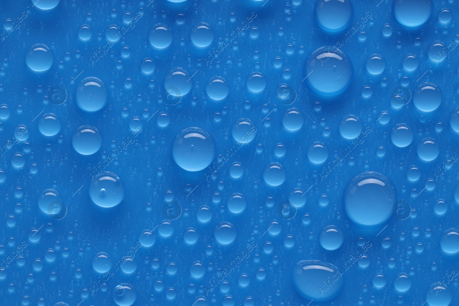 Photo of Water drops on blue background, top view