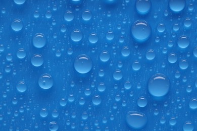 Photo of Water drops on blue background, top view