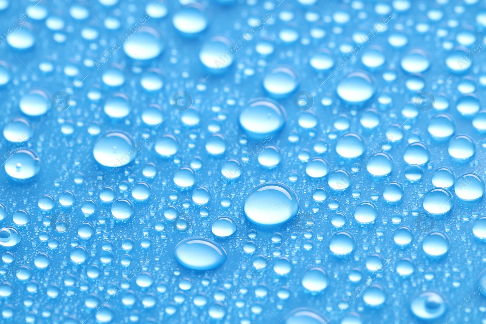 Photo of Water drops on blue background, closeup view