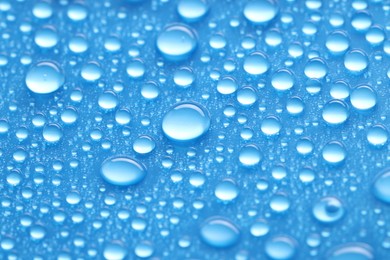 Water drops on blue background, closeup view