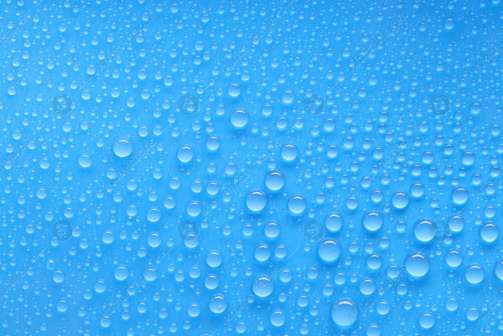 Photo of Water drops on blue background, top view