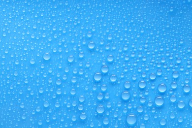 Photo of Water drops on blue background, top view