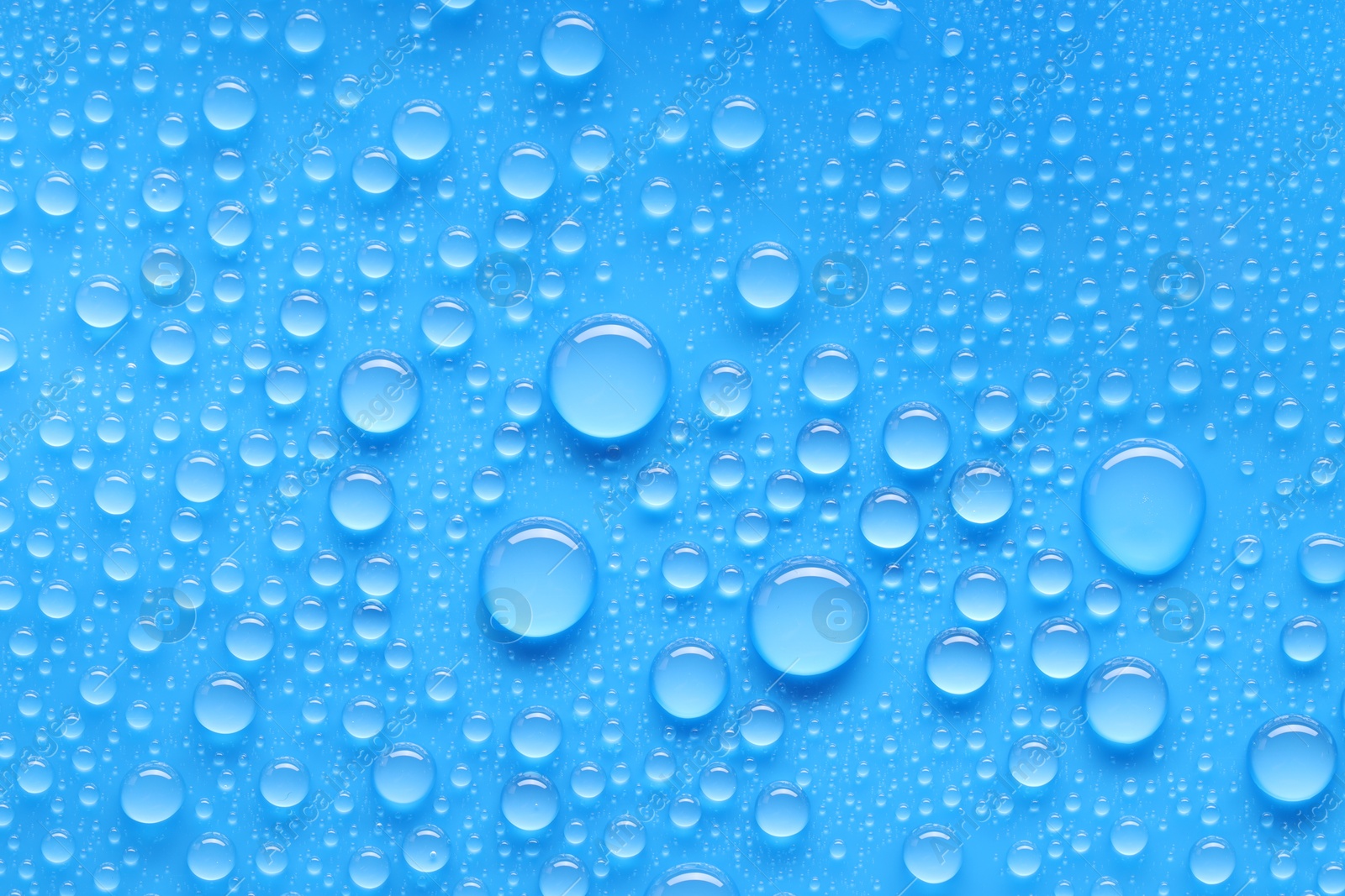 Photo of Water drops on blue background, top view