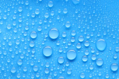 Photo of Water drops on blue background, top view