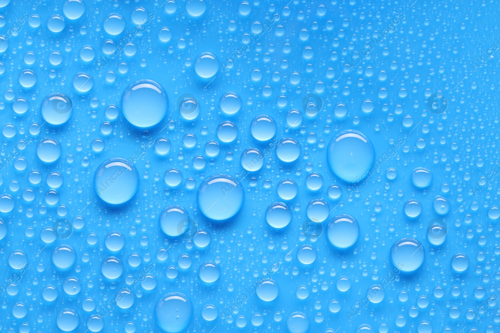 Photo of Water drops on blue background, top view