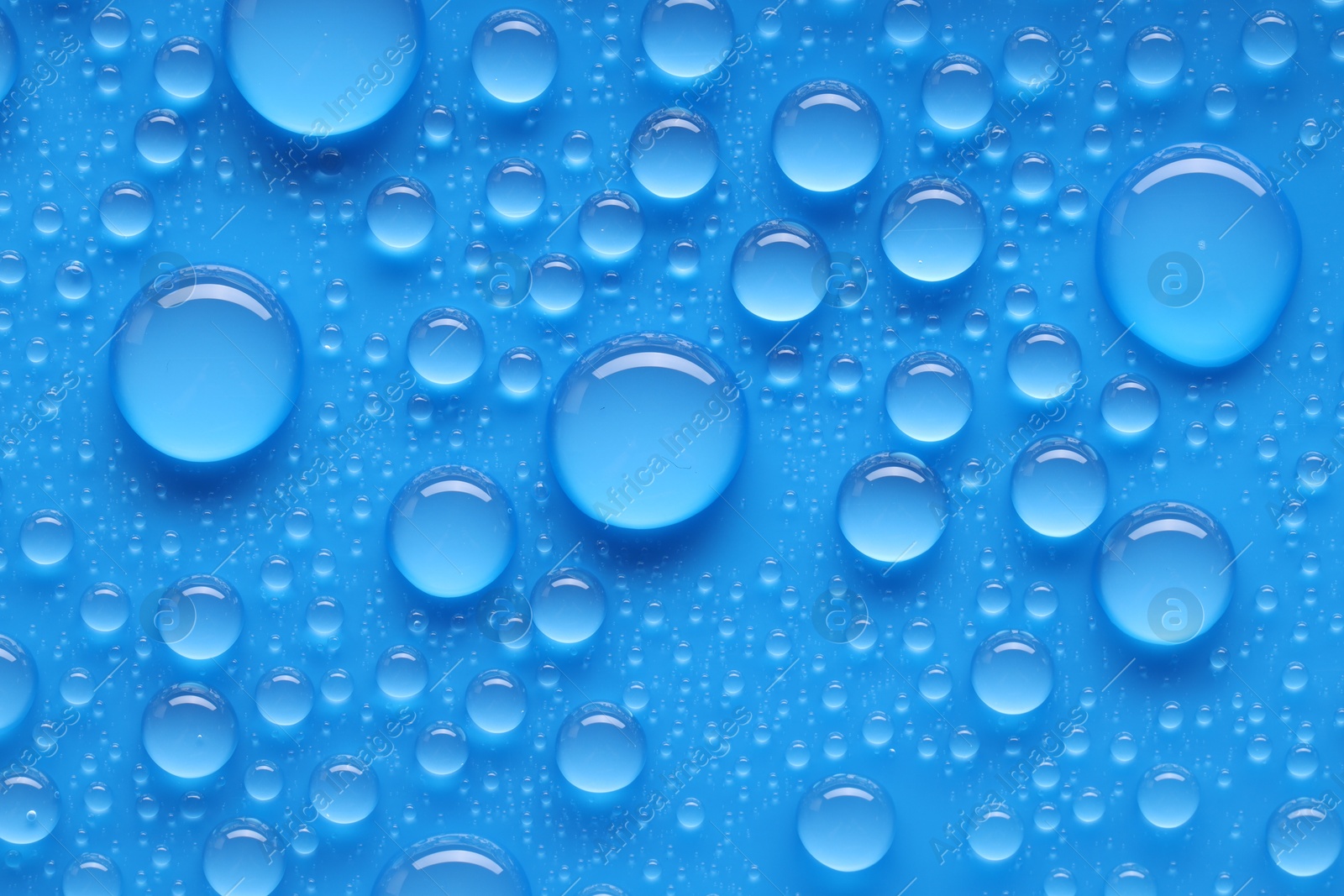 Photo of Water drops on blue background, top view