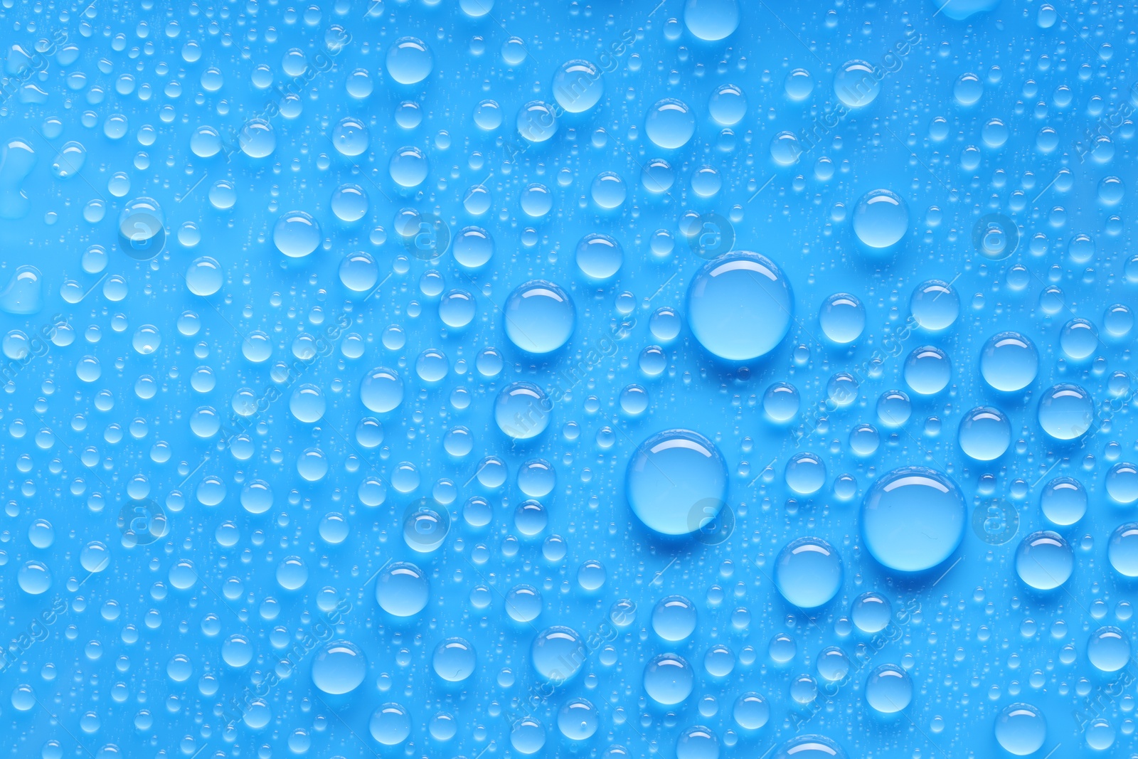 Photo of Water drops on blue background, top view