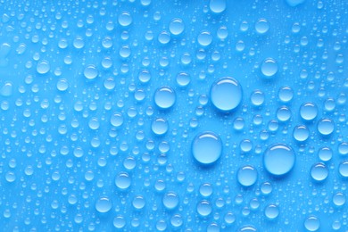 Photo of Water drops on blue background, top view