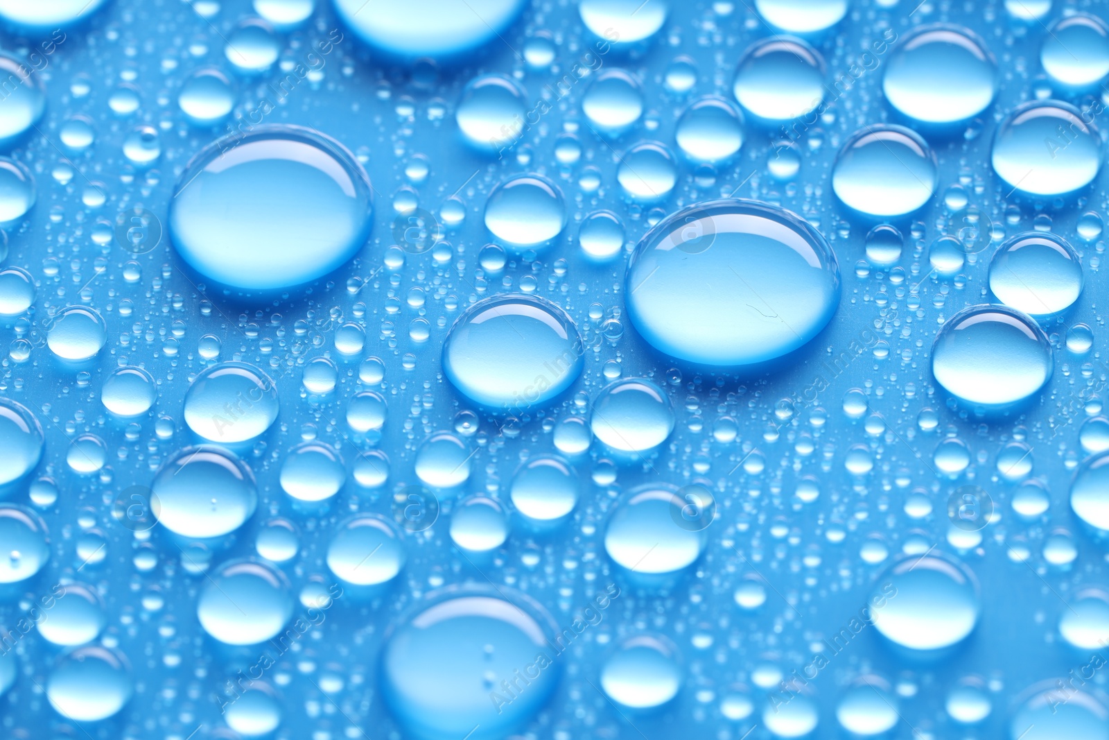 Photo of Water drops on blue background, closeup view