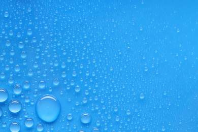 Photo of Water drops on blue background, top view