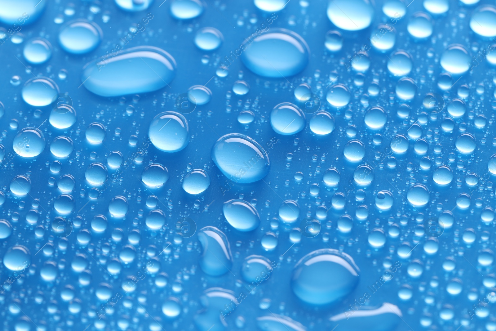 Photo of Water drops on blue background, closeup view