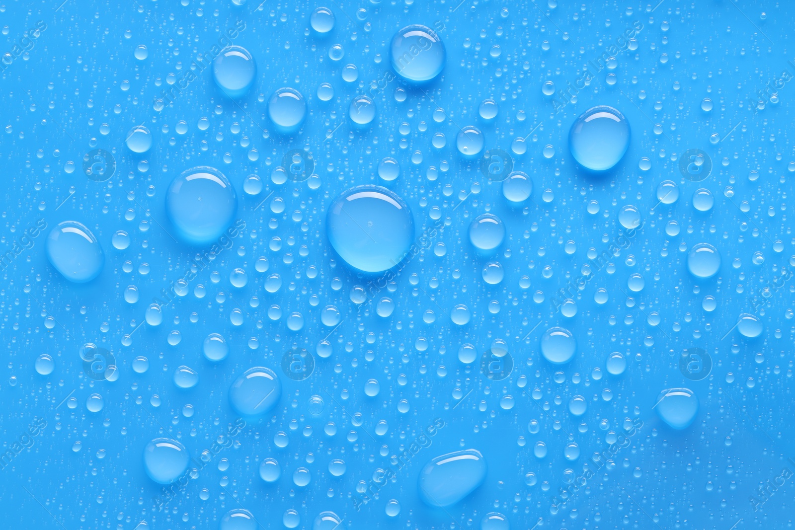 Photo of Water drops on blue background, top view