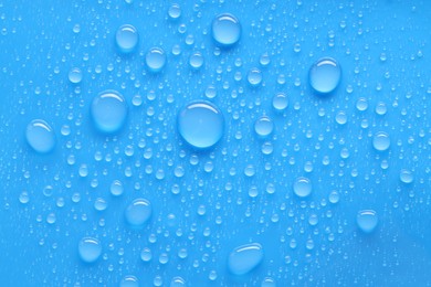 Photo of Water drops on blue background, top view