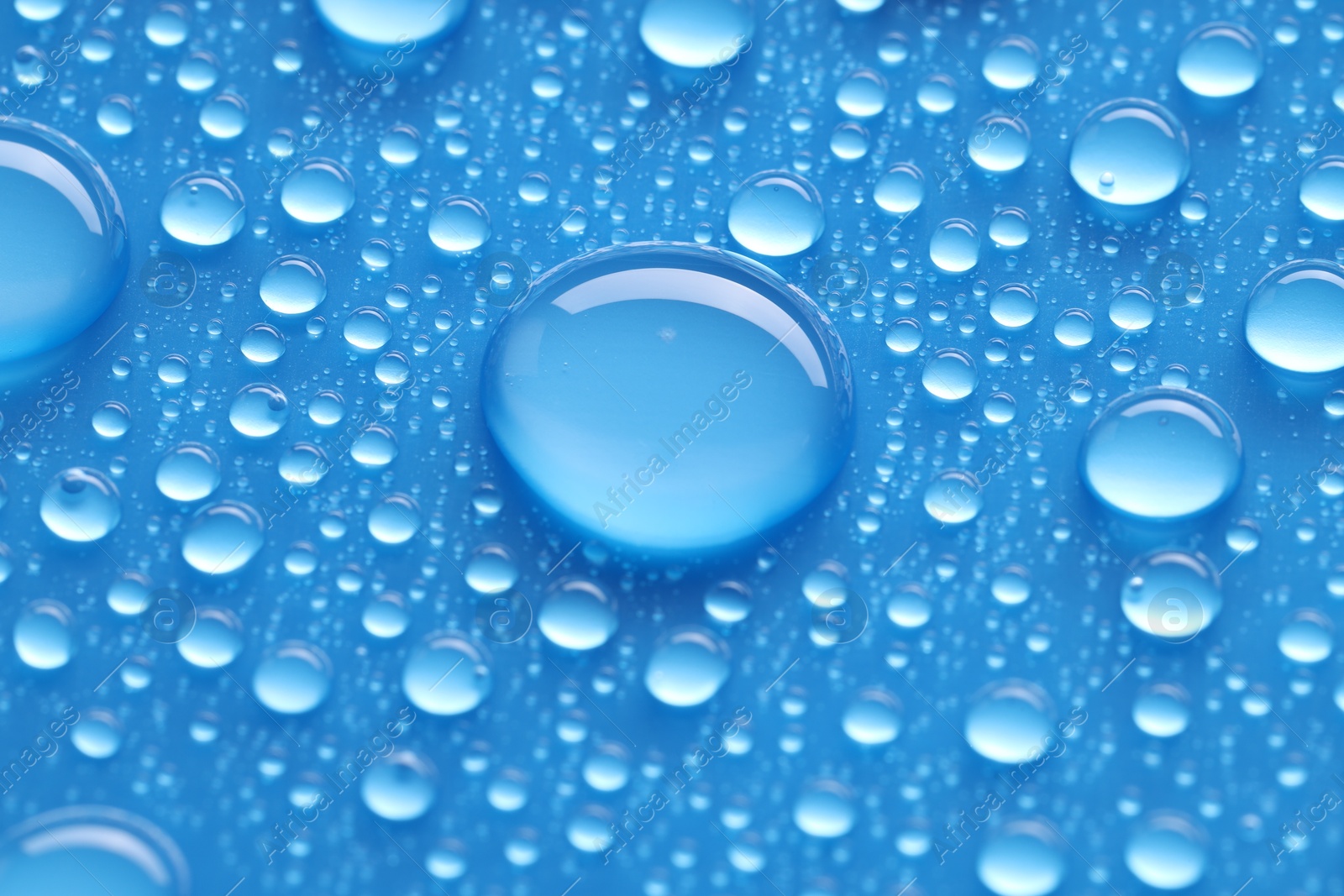 Photo of Water drops on blue background, closeup view