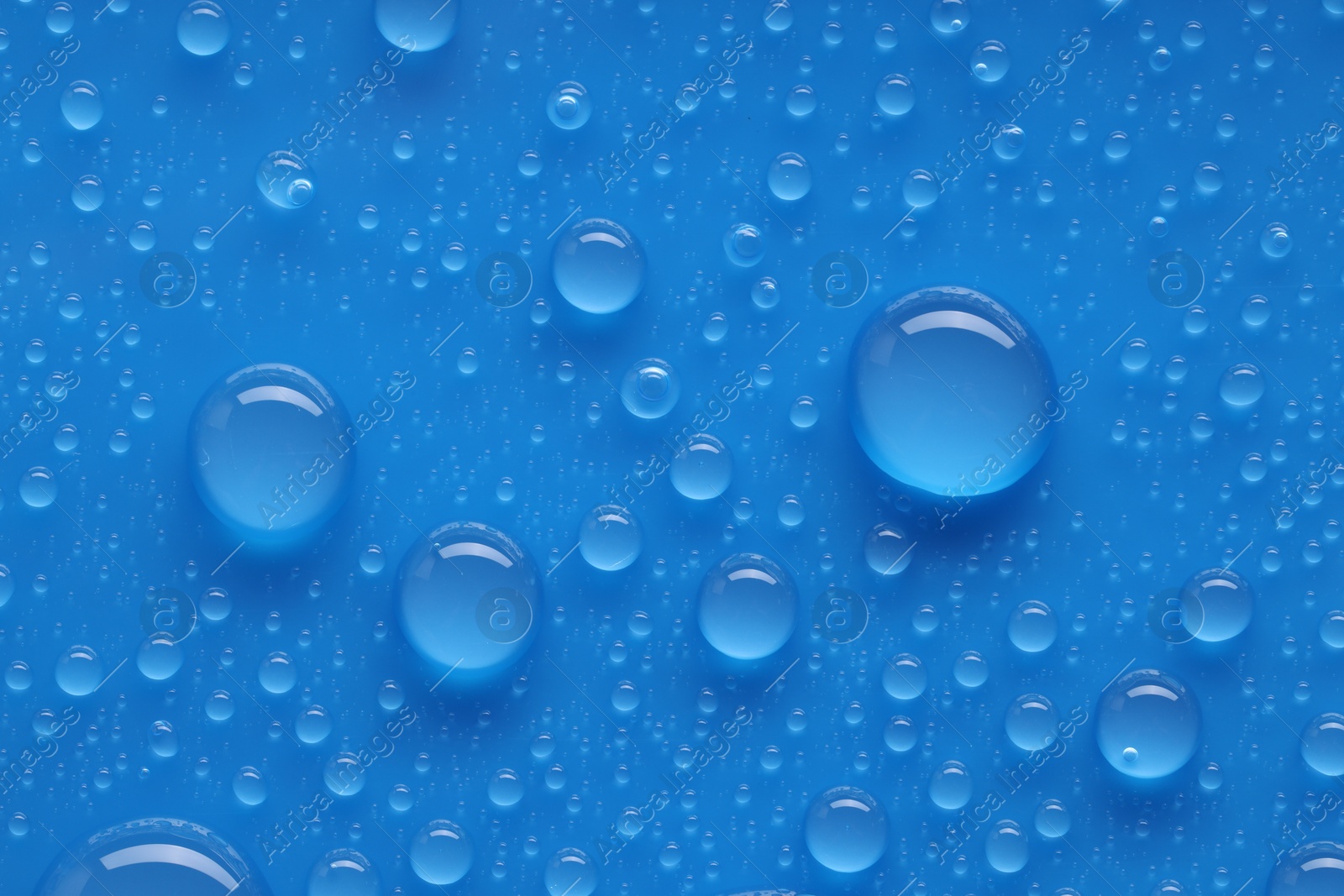 Photo of Water drops on blue background, top view