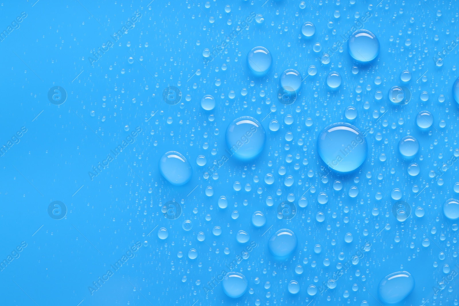 Photo of Water drops on blue background, top view