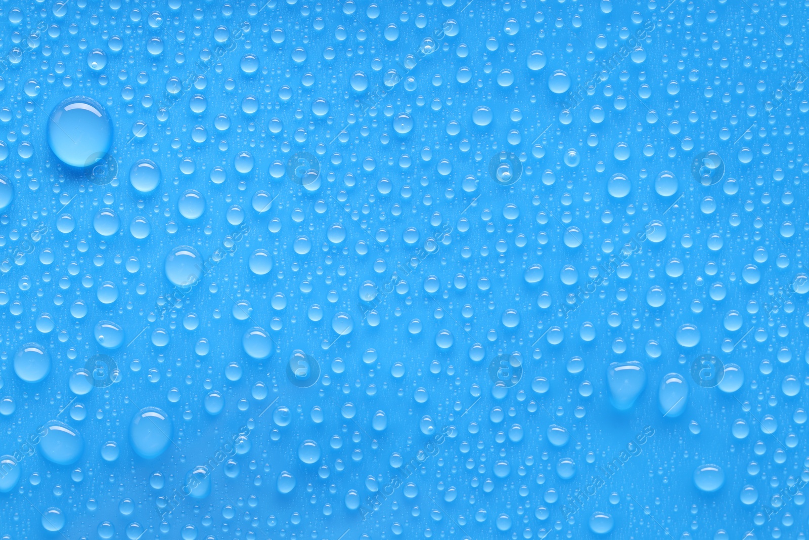 Photo of Water drops on blue background, top view