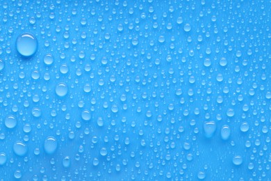 Photo of Water drops on blue background, top view