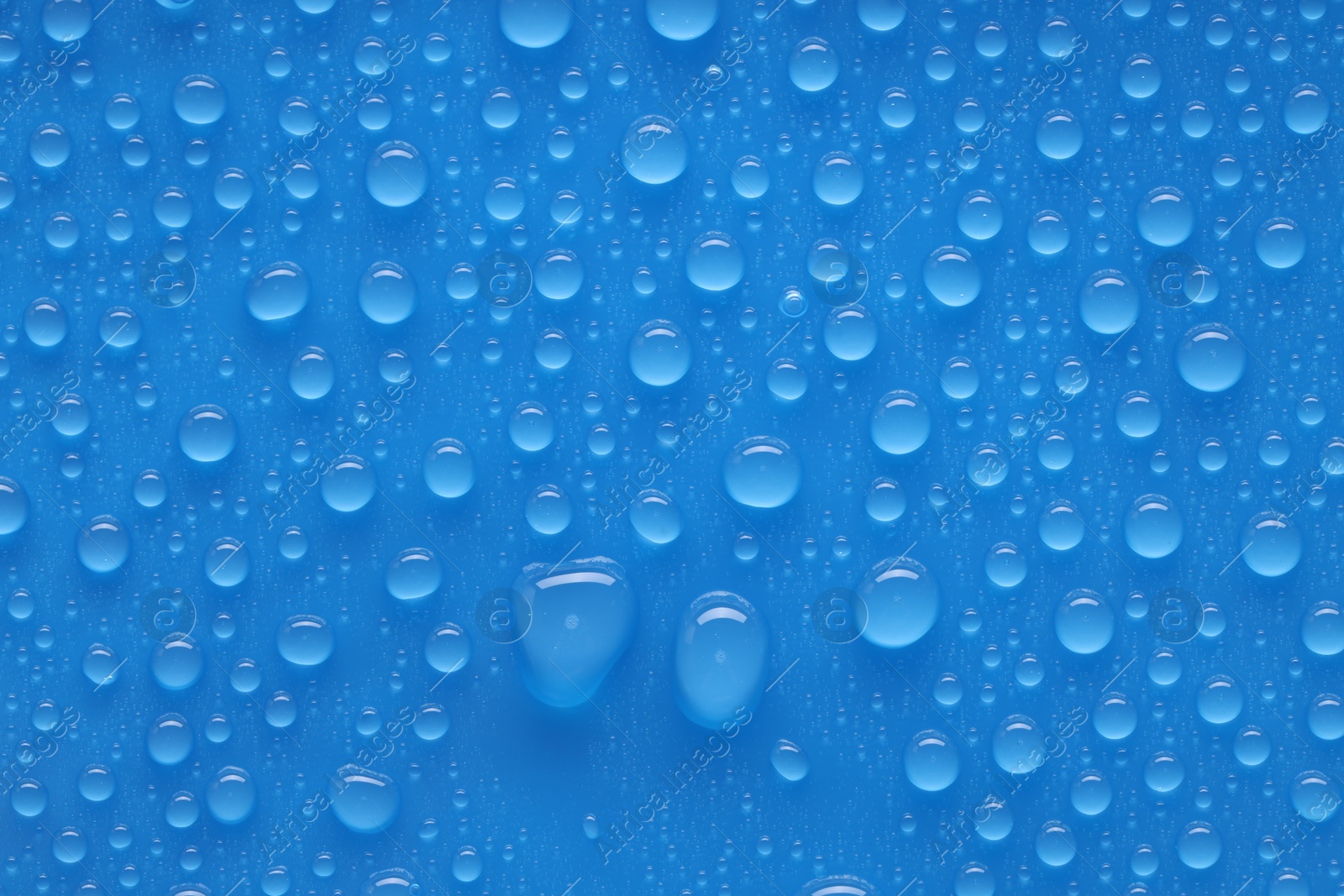 Photo of Water drops on blue background, top view