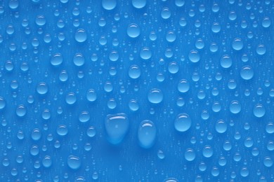 Photo of Water drops on blue background, top view