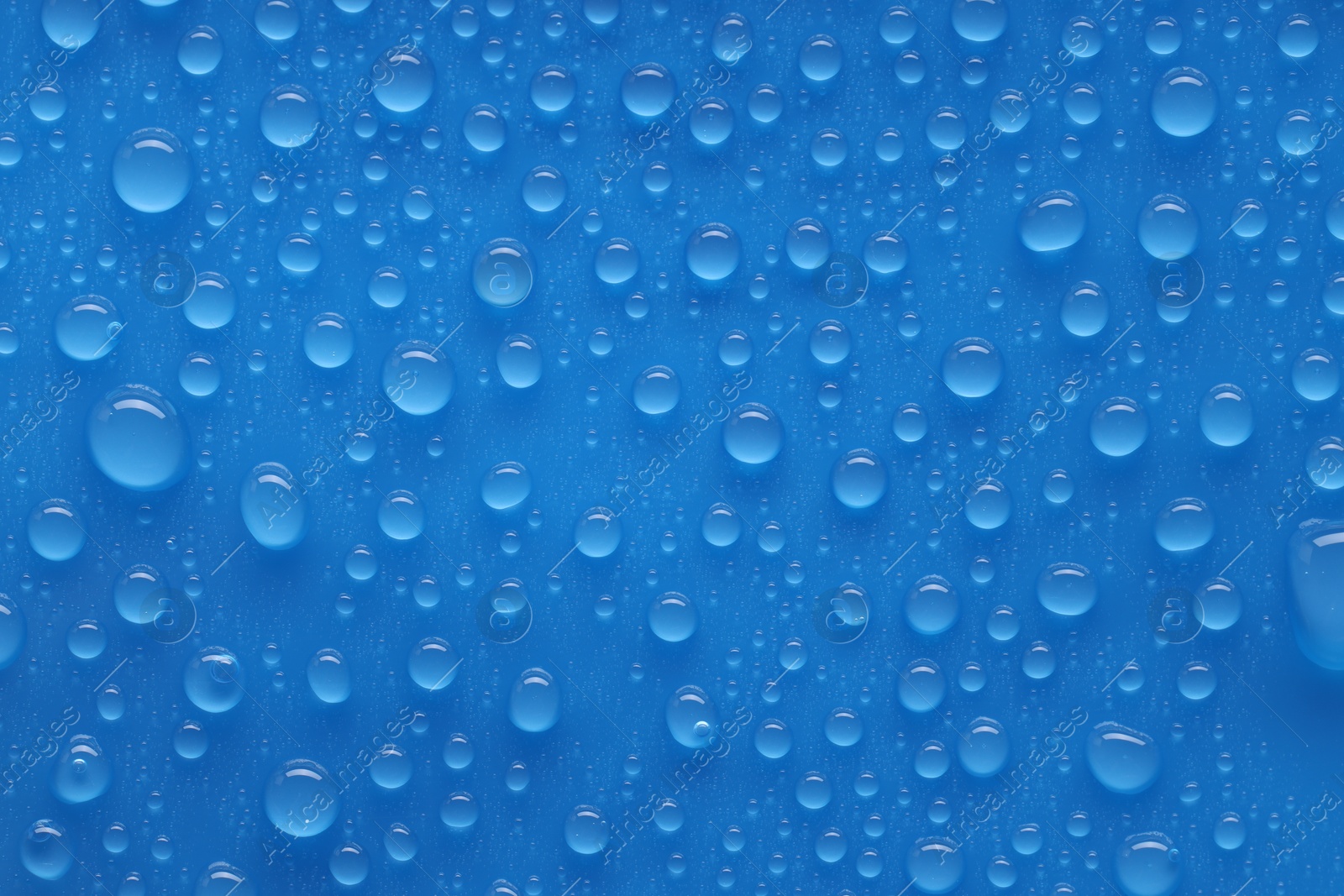 Photo of Water drops on blue background, top view