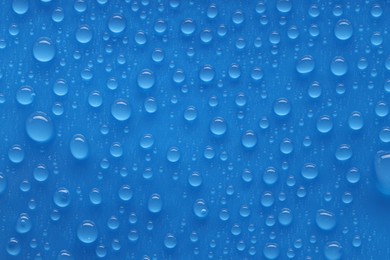 Photo of Water drops on blue background, top view