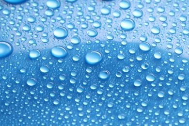 Photo of Water drops on blue background, closeup view