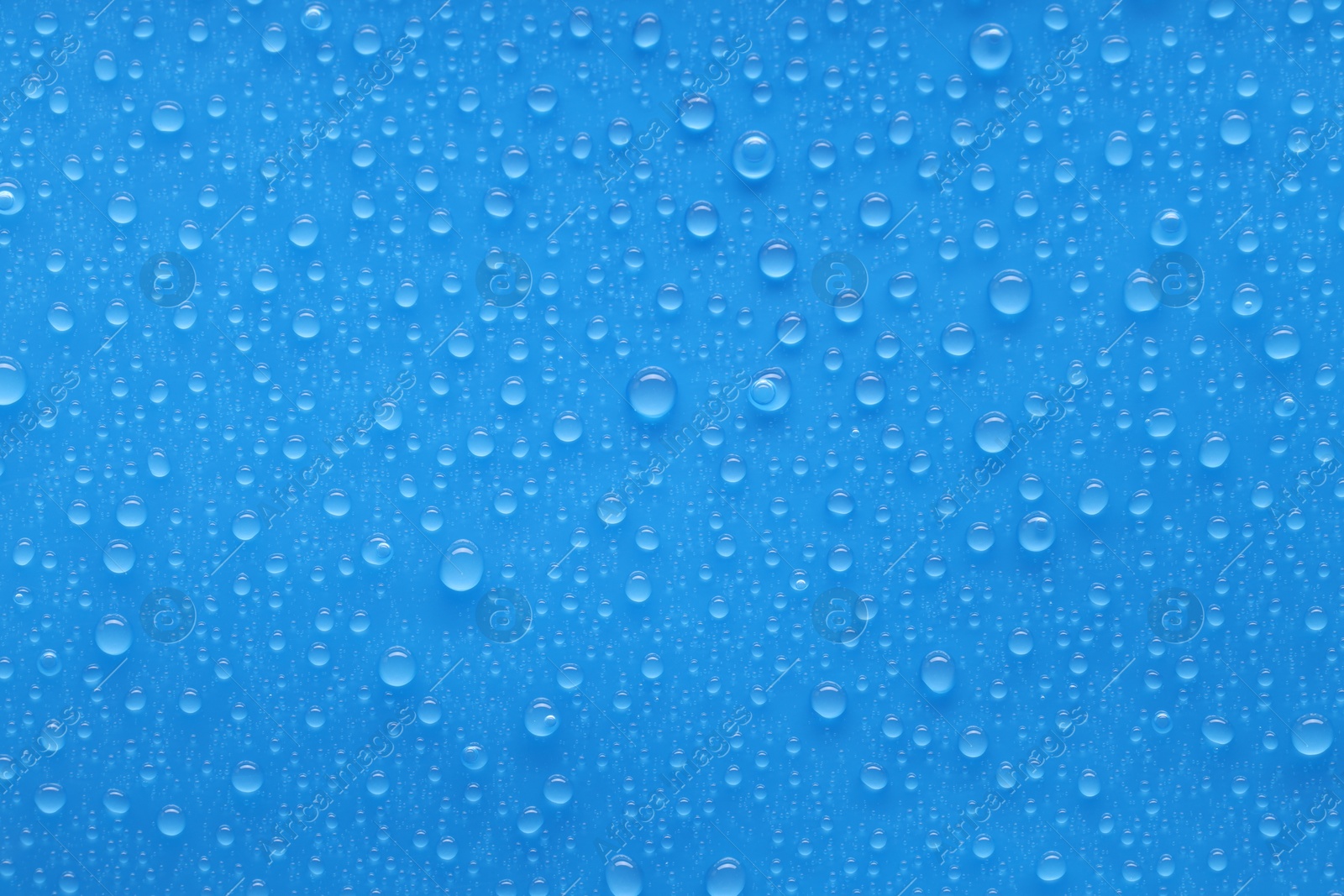 Photo of Water drops on blue background, top view