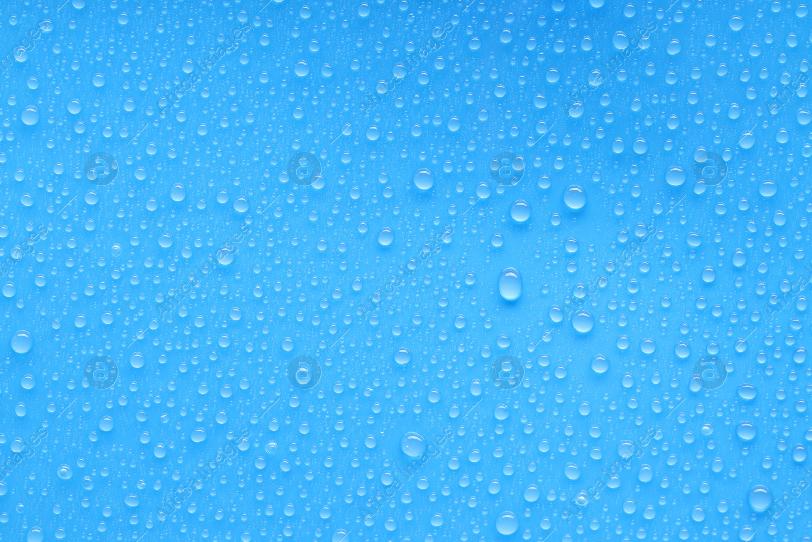 Photo of Water drops on blue background, top view