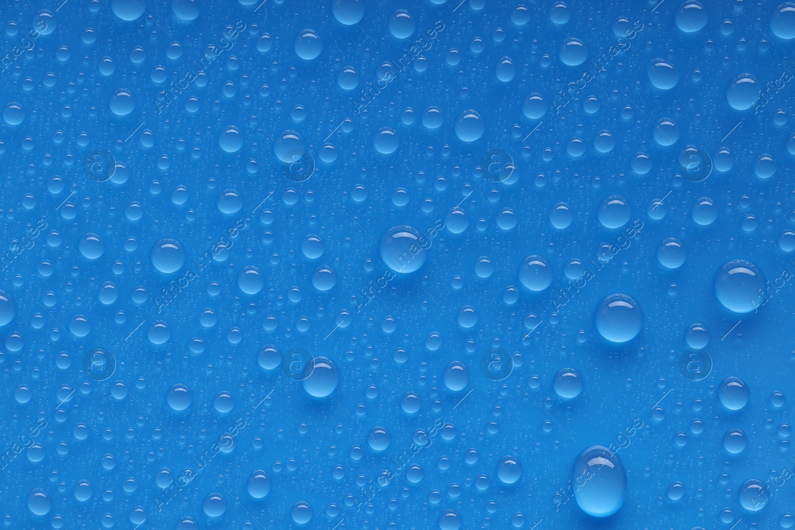 Photo of Water drops on blue background, top view