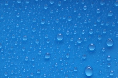 Photo of Water drops on blue background, top view