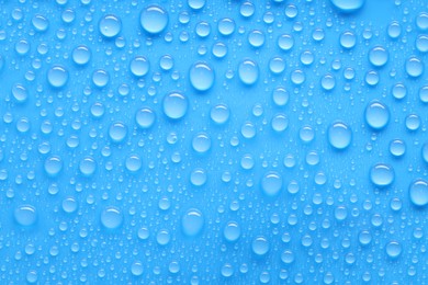 Photo of Water drops on blue background, top view