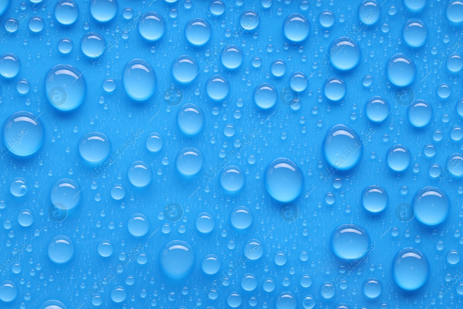 Photo of Water drops on blue background, top view