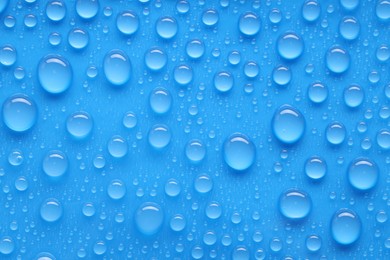 Photo of Water drops on blue background, top view