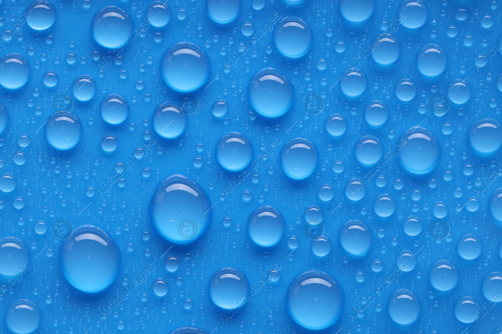 Photo of Water drops on blue background, top view