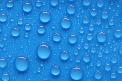 Photo of Water drops on blue background, top view