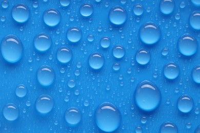 Photo of Water drops on blue background, top view