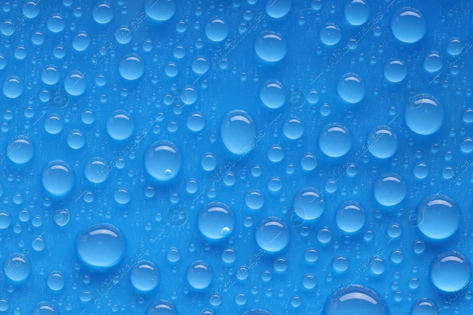 Photo of Water drops on blue background, top view